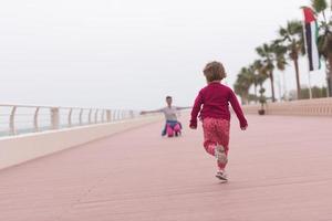 madre e carino poco ragazza su il lungomare di il mare foto