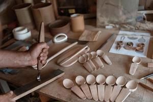 mani intaglio cucchiaio a partire dal Di legno, Lavorando con scalpello vicino su. di legno officina. processi di fabbricazione di legno cucchiaio foto