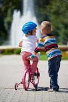 ragazzo e ragazza nel parco apprendimento per cavalcata un' bicicletta foto