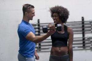 nero donna fare bicipite riccioli con fitness allenatore foto