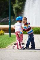 ragazzo e ragazza nel parco apprendimento per cavalcata un' bicicletta foto