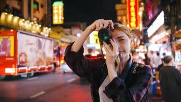 un' femmina turista gode assunzione fotografie di il notte Visualizza di Yaowarat strada o chinatown nel bangkok, Tailandia.