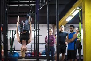 donna Lavorando su con personale allenatore su ginnastica anelli foto