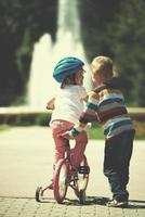 ragazzo e ragazza nel parco apprendimento per cavalcata un' bicicletta foto