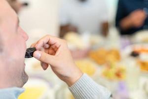 moderno multietnico musulmano famiglia condivisione un' ciotola di date foto