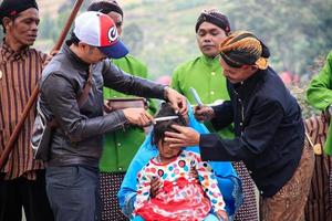 dieng, Indonesia - agosto 1, 2015. dieng cultura Festival, turisti Seguire il dreadlocks processione durante il dieng cultura Festival evento a dieng, banjarnegara quartiere, centrale Giava foto