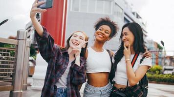 un' gruppo di multietnico femmina amici godendo il città tour. giovane turisti avendo divertimento assunzione immagini insieme. foto