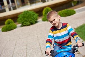 contento ragazzo apprendimento per cavalcata il suo primo bicicletta foto