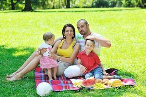 felice giovane coppia con i loro bambini si divertono al parco foto