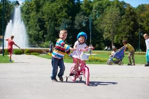 ragazzo e ragazza nel parco apprendimento per cavalcata un' bicicletta foto