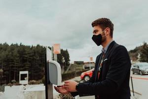 uomo utilizzando lavare mano disinfettante gel distributore adottando per impedire il diffusione di il coronavirus foto