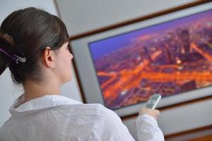 giovane donna Guardando tv a casa foto