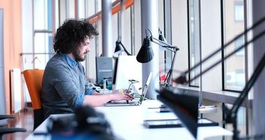 uomo d'affari che lavora utilizzando un laptop nell'ufficio di avvio foto