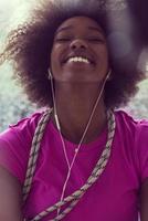 ritratto di giovane afro americano donna nel Palestra mentre ascoltando musica foto