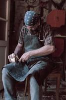 cucchiaio mestiere maestro nel il suo laboratorio con fatto a mano di legno prodotti e utensili Lavorando foto