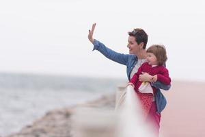 madre e carino poco ragazza su il lungomare di il mare foto