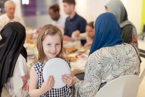 carino poco ragazza godendo iftar cena con famiglia foto