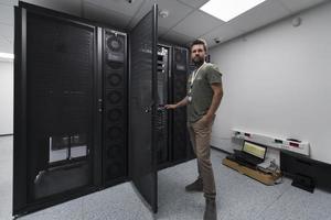 dati centro ingegnere usando tastiera su un' supercomputer server camera specialista servizio, struttura con maschio sistema amministratore foto