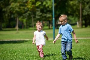 ragazzo e ragazza avere divertimento e in esecuzione nel parco foto