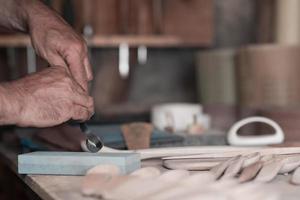 mani intaglio cucchiaio a partire dal Di legno, Lavorando con scalpello vicino su. di legno officina. processi di fabbricazione di legno cucchiaio foto