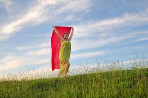 bella donna con sciarpa rossa sul prato foto