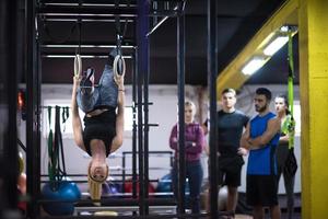 donna Lavorando su con personale allenatore su ginnastica anelli foto