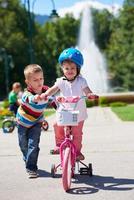 ragazzo e ragazza nel parco apprendimento per cavalcata un' bicicletta foto