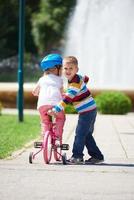 ragazzo e ragazza nel parco apprendimento per cavalcata un' bicicletta foto