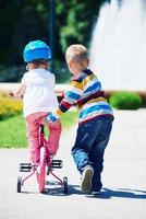 ragazzo e ragazza nel parco apprendimento per cavalcata un' bicicletta foto