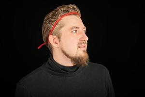 divertente uomo barbuto con fascia rossa, sfondo nero foto
