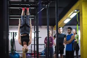 donna Lavorando su con personale allenatore su ginnastica anelli foto