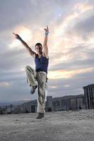 giovane uomo danza e salto su superiore di il edificio foto