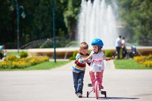 ragazzo e ragazza nel parco apprendimento per cavalcata un' bicicletta foto