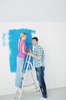 contento coppia dipingere parete a nuovo casa foto