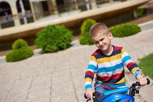 contento ragazzo apprendimento per cavalcata il suo primo bicicletta foto