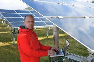 ingegnere utilizzando il computer portatile a solare pannelli pianta campo foto