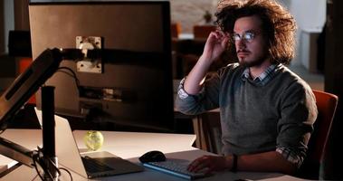 uomo Lavorando su computer nel buio ufficio foto