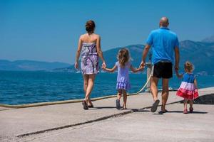 giovane contento famiglia a piedi di il mare foto