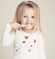 bambina divertente in pigiama con spazzolino da denti foto