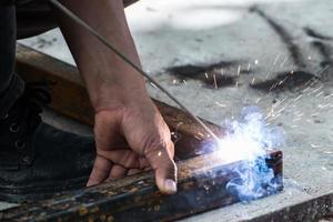 lavoratore saldatura acciaio con illuminazione scintille foto