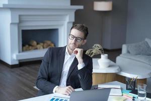 un uomo d'affari riposante in abiti formali si siede a casa in ufficio con gli occhi chiusi mentre lavora in remoto online foto