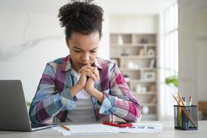 la studentessa ha problemi di concentrazione. la ragazza afroamericana oberata di lavoro sta studiando a distanza a casa. foto