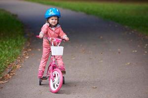 poco ragazza con bicicletta foto