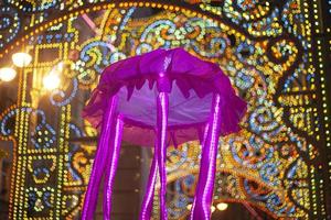 festivo mascherata. raggiante Medusa nel il modulo di un ombrello. notte città vita per un' vacanza. divertente cittadini con vivace oggetti. foto