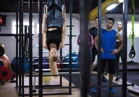 donna Lavorando su con personale allenatore su ginnastica anelli foto