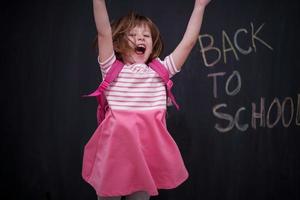 scuola ragazza bambino con zaino scrittura lavagna foto