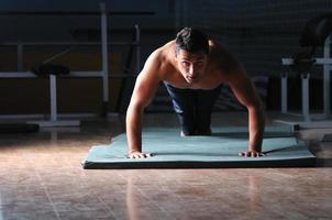 giovane uomo con forte braccia Lavorando su nel Palestra foto