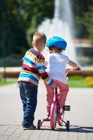 ragazzo e ragazza nel parco apprendimento per cavalcata un' bicicletta foto