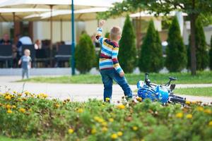 contento ragazzo apprendimento per cavalcata il suo primo bicicletta foto