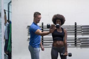 nero donna fare bicipite riccioli con fitness allenatore foto